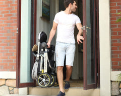 Three Wheels Baby Stroller Baby Pram folded and carried by a father  Three Wheels Baby Stroller Baby Pram folded and carried by a father